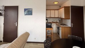 A compact living space with a kitchenette, a dining area with a table and chairs, and a sofa. - Seignosse Ocean, apartment rated 2 stars, right next to Penon beach (SEIGNOSSE)