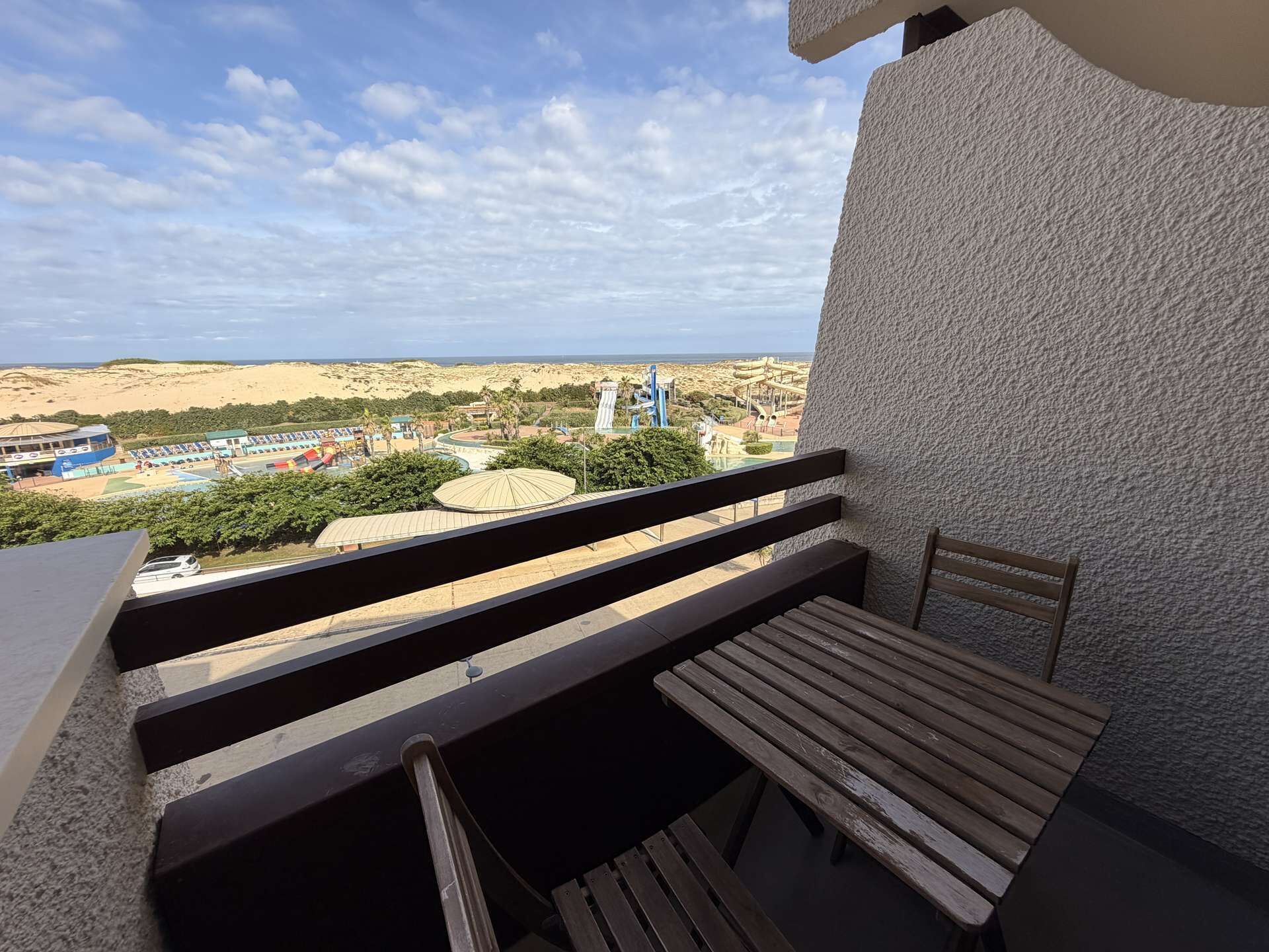 Varanda com vista para a praia e parque aquático.