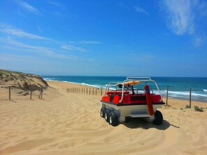 A beach with a red and white vehicle parked on the sand. - Seignosse Ocean, apartment with SEA VIEW, right next to the beach, 4 people (SEIGNOSSE)