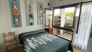 A room with a bed, a chair, a window, and artwork on the wall. - Seignosse Ocean, apartment near the beach and town center, 4 people (SEIGNOSSE)