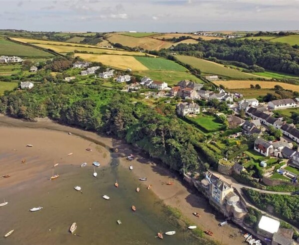 A coastal village with houses, a beach, and boats.