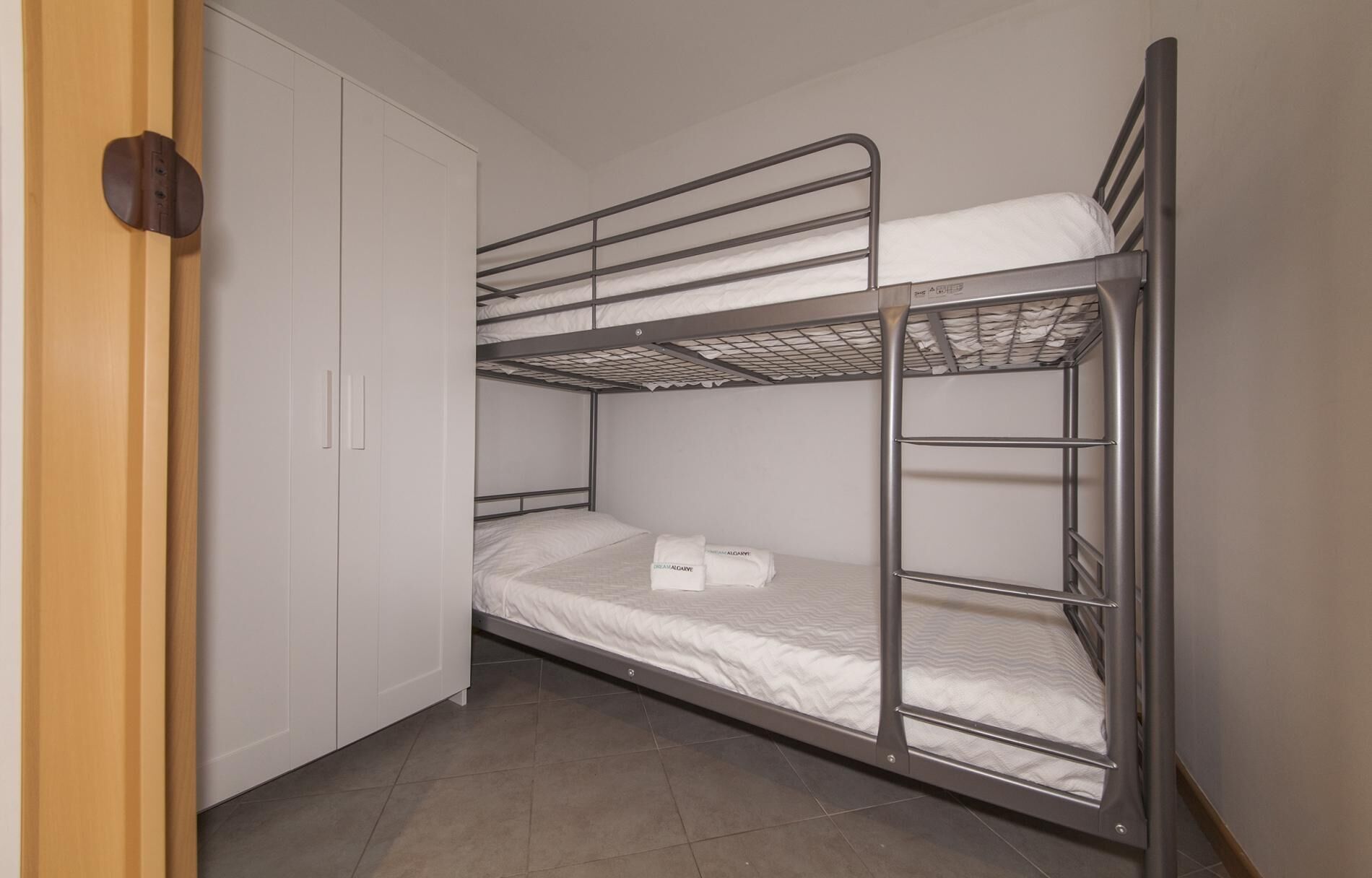 Dormitorio con literas, armario y puerta.