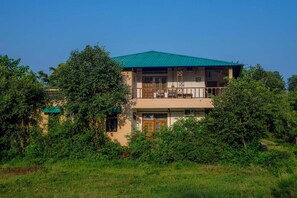 A two-story building with a green roof, surrounded by lush greenery. - The Rangers reserve Jim Corbett (Nainital)