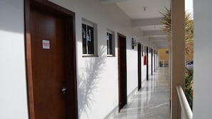 A corridor with doors numbered 107, leading to rooms. - Pousada Santana (Trindade)
