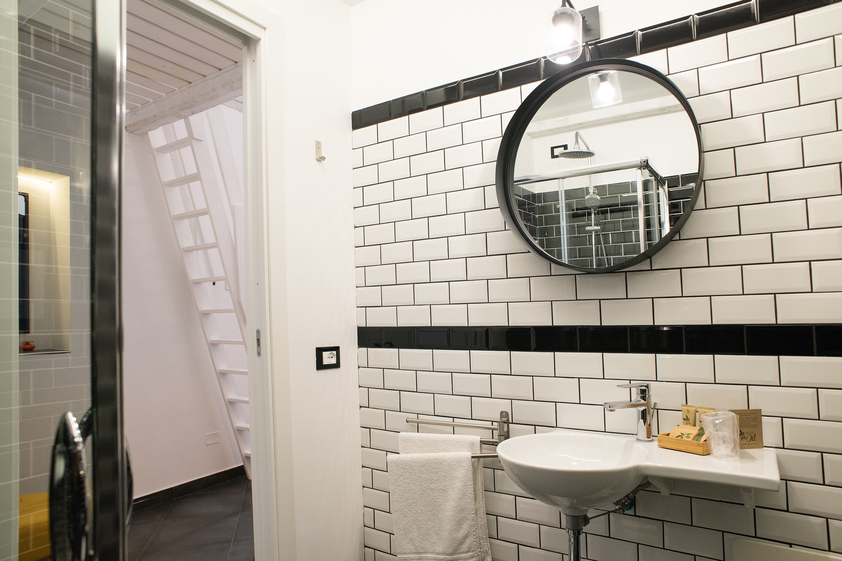 Ein Badezimmer mit einem weißen Waschbecken, einem Spiegel und einem Handtuchhalter.