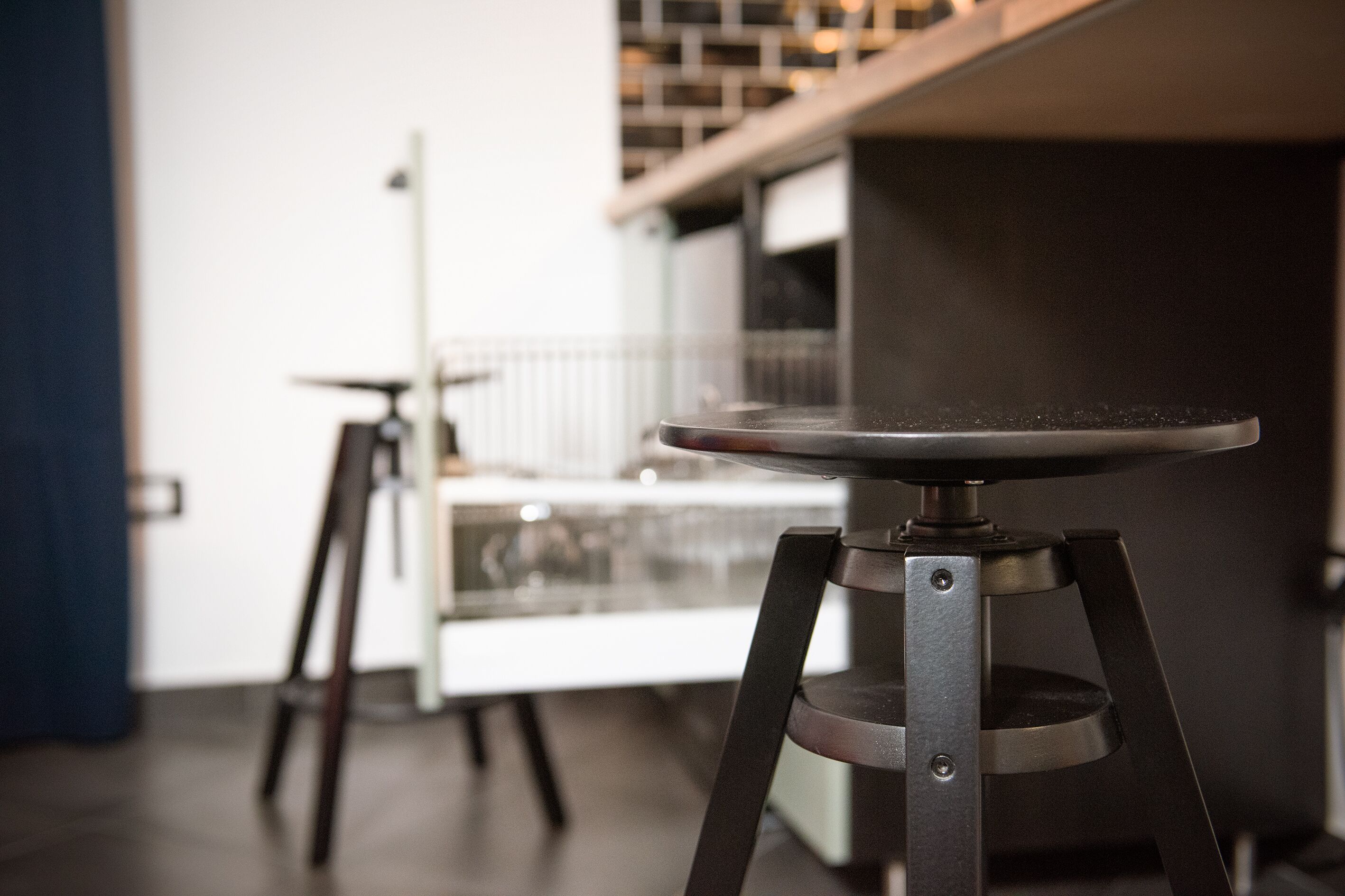 Une cuisine moderne dotée d’un îlot central et de deux tabourets de bar.