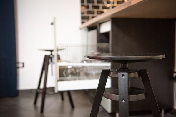 A modern kitchen with a central island and two bar stools. - InCentro B&B (Milazzo)