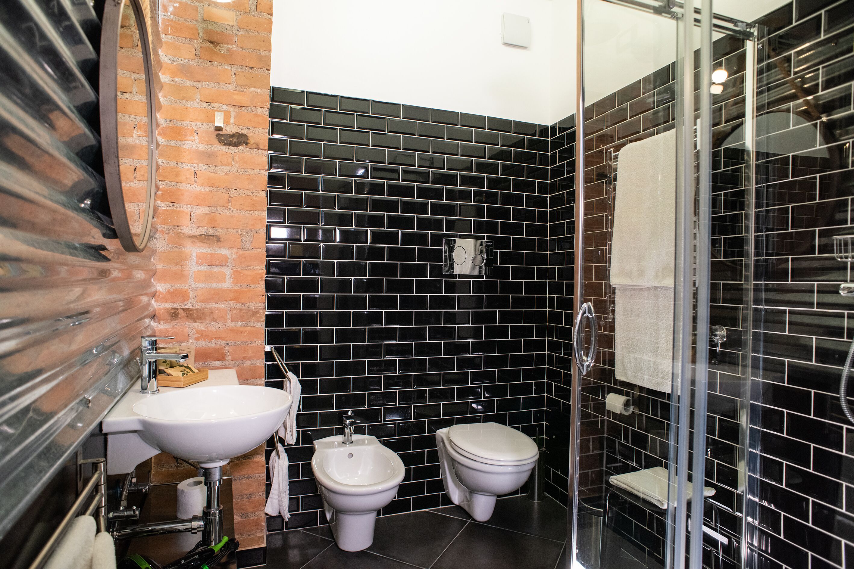 Une salle de bain équipée d’un lavabo, d’un bidet et d’une douche à parois en verre.