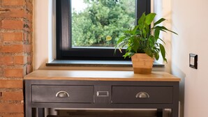 Un bureau en bois avec deux tiroirs et une plante en pot.