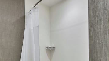 A modern bathroom with a white bathtub, a shower curtain, and a towel rack.