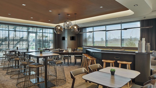 Un restaurant moderne doté de plusieurs espaces de restauration, de grandes fenêtres offrant une vue dégagée et d’un éclairage contemporain.