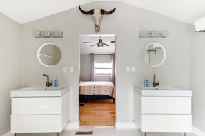 A bedroom with a bed, two bedside tables, a ceiling fan, and a large mirror. - Lady Bird House ATX walk to Rainey, Cesar Chavez and 6 street (Austin)