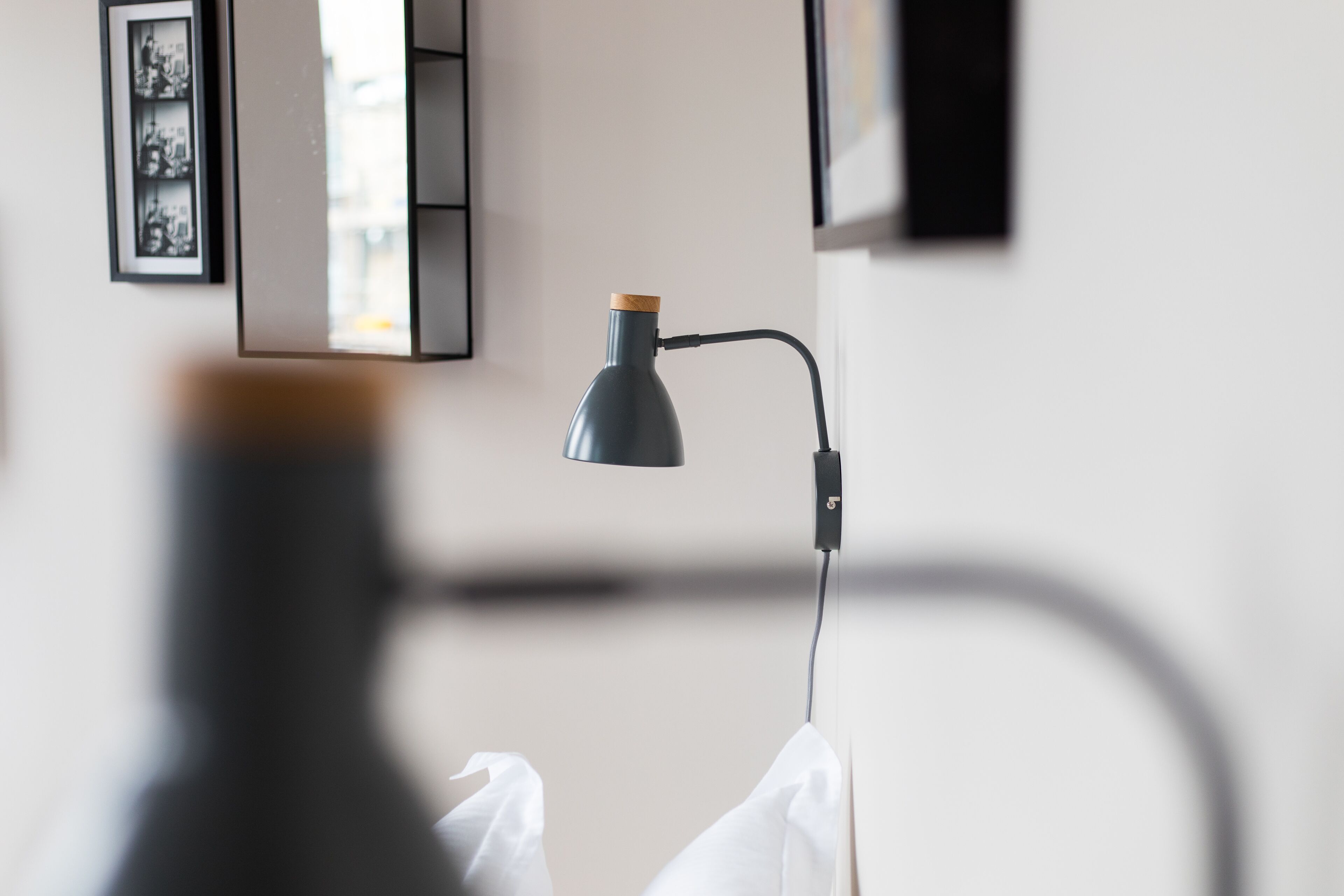 A room with a desk lamp, a framed picture on the wall, and a white cloth on the floor.