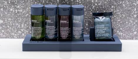 A bathroom sink area with four bottles of Anyah spa treatment products and a packet of body cream.