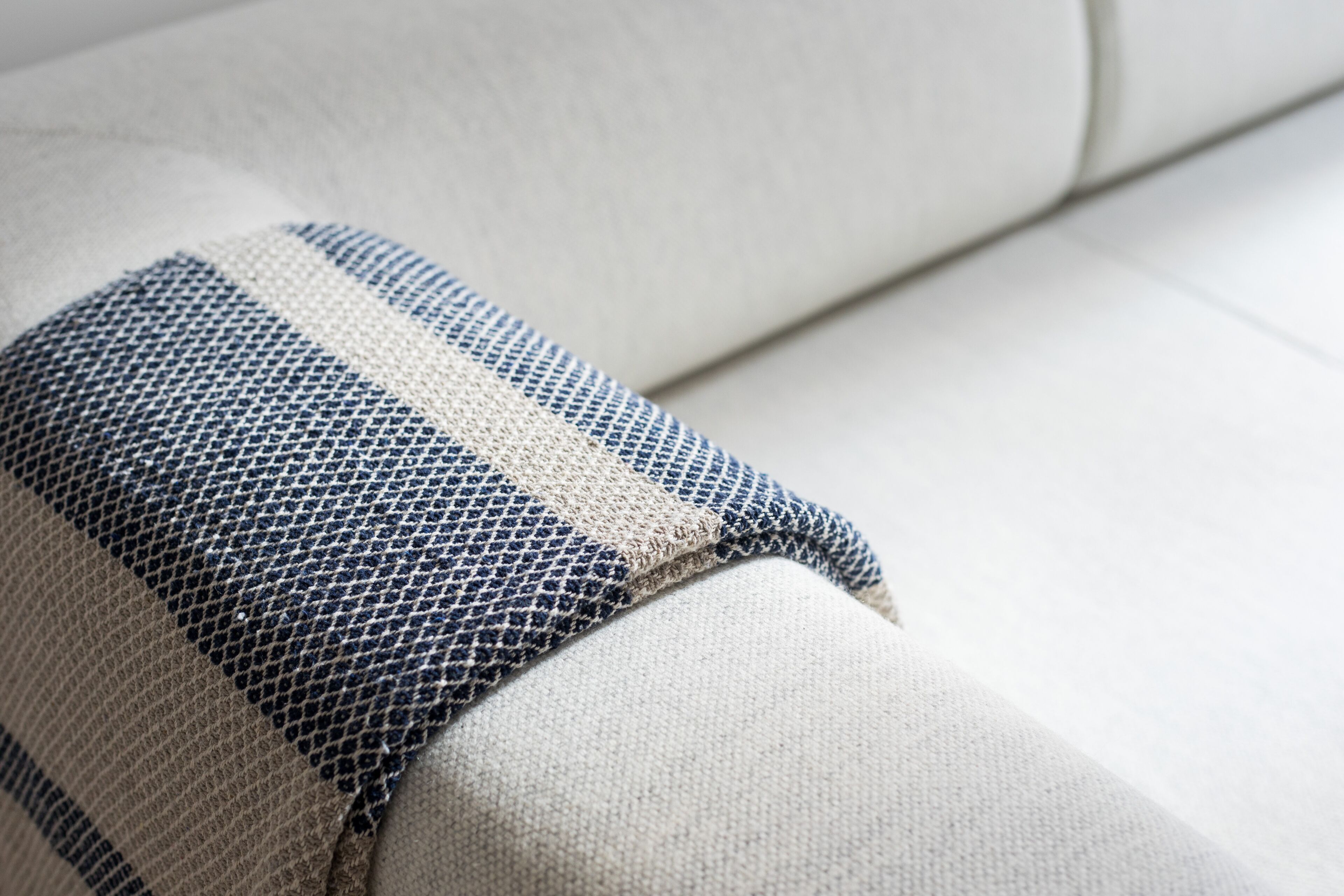 A close-up of a sofa with a striped fabric cushion.