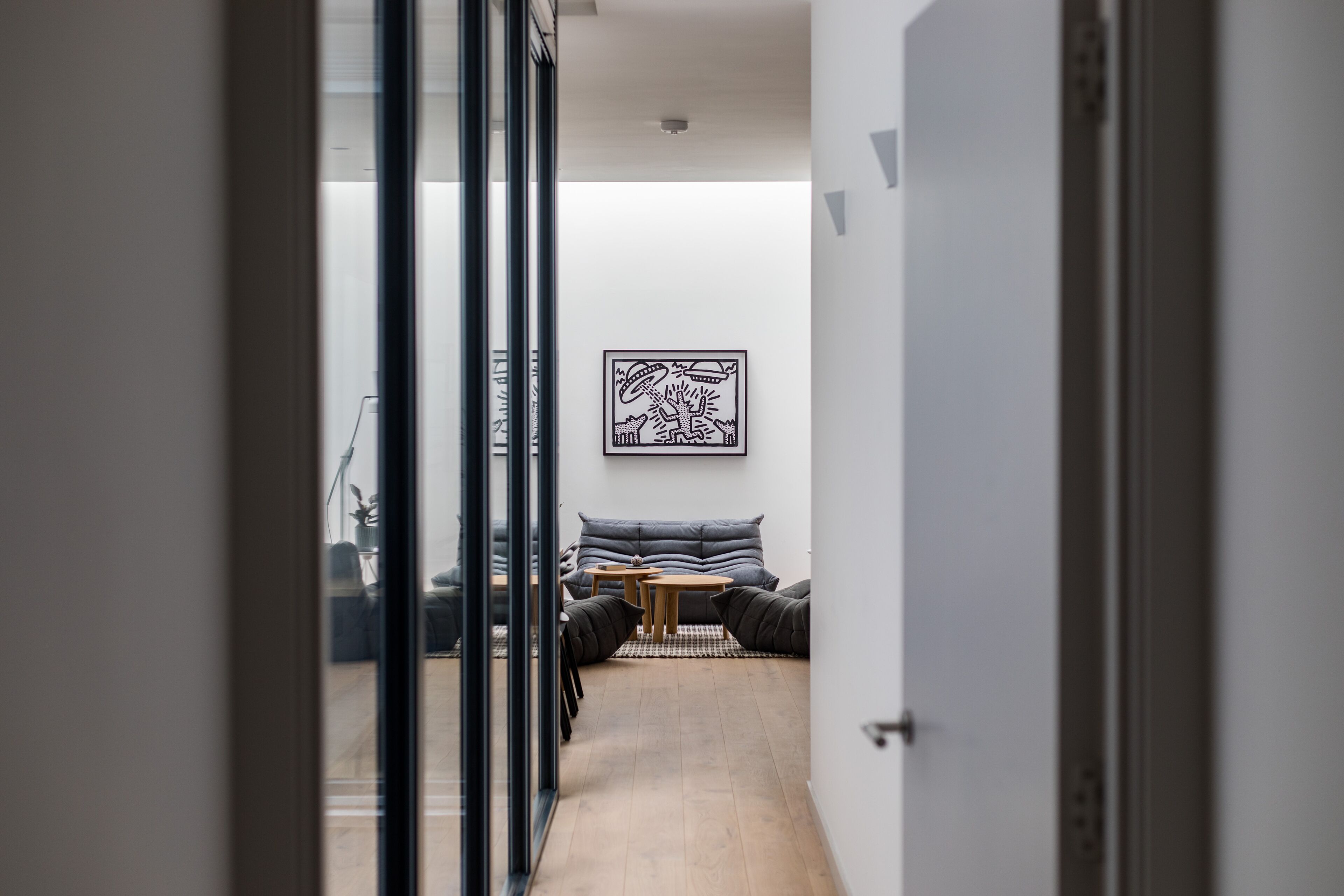 A modern interior with a sofa set, a small table, and a framed artwork on the wall.