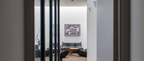 A modern interior with a sofa set, a small table, and a framed artwork on the wall.