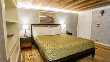 A bedroom with a bed, nightstands, a lamp, a painting, a wardrobe, and a patterned rug.