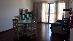 A room with a dining table and chairs, a bunk bed, a TV, and a window with curtains. - Departamento Sarmiento Salta (Salta)
