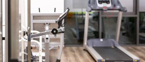 A gym with exercise equipment and a treadmill.