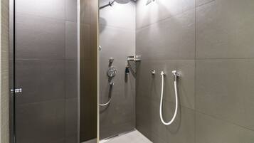 Un espace douche moderne doté d’une porte en verre et d’un pommeau de douche.
