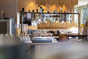 Una cocina moderna con detalles de madera, lámparas colgantes y una mesa de buffet.