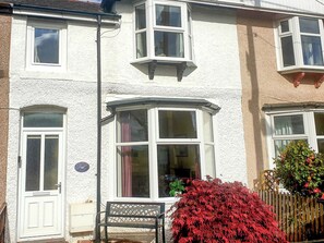 A two-story house with a bay window, a front door, and a small garden with red foliage. - 2 bedroom accommodation in Creetown, near Newton Stewart (Creetown, near Newton Stewart)