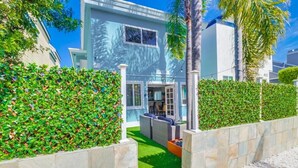 A modern building with a well-maintained lawn, outdoor seating area, and a stone wall. - Beautiful Apartment 5 minutes from the ocean (San Diego)