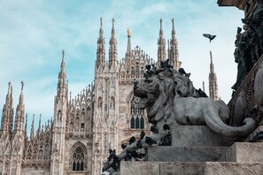 A Gothic cathedral with intricate spires and a lion statue.