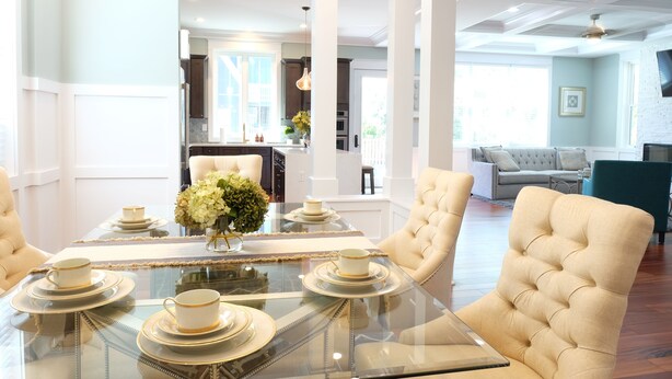 A dining area with a glass table, white chairs, and a chandelier. - Luxury brand-new home mins away from Washington DC (Arlington)