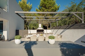 An outdoor patio with a pergola, seating, and a grill. - The Divine Villa of Zakynthos (Zakynthos (Zante))