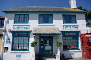 A two-story building with signs for 'Bantham Village Stores' and 'Coffee Shop & Terrace.'