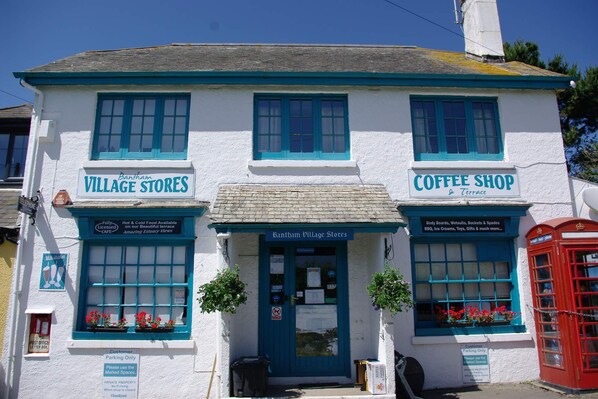A two-story building with signs for 'Bantham Village Stores' and 'Coffee Shop & Terrace.'