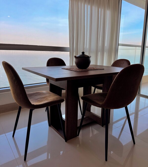 A dining table with four chairs, a pot on the table, and a view of the sea through large windows. - STUNNING SEA VIEW, YOU'LL LOVE IT!! RNT96045 (Cartagena)