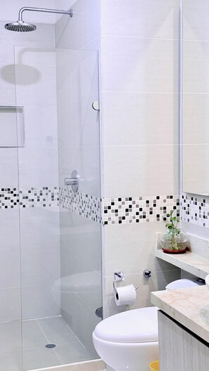 A modern bathroom with a glass shower enclosure, a toilet, and a sink with a marble countertop. - STUNNING SEA VIEW, YOU'LL LOVE IT!! RNT96045 (Cartagena)