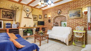 Ein gemütliches Wohnzimmer mit Kamin, einer Couch, einem Couchtisch und einem Fernseher.