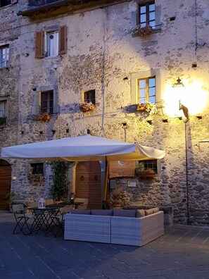 A stone building with a rustic exterior, a wooden door, and a sign indicating a restaurant. - Luna & Stelle (Villafranca in Lunigiana)