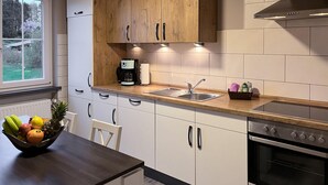 Een moderne keuken met houten kastjes, een roestvrijstalen spoelbak en een ingebouwde oven.