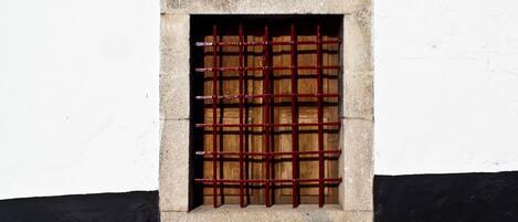 A window with a metal grid, a number '1820' above it, and a black and white wall.
