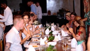 A formal dining setting with guests seated at a long table, decorated with white napkins and floral centerpieces. - Somerset Mirissa Beach (Mirissa)
