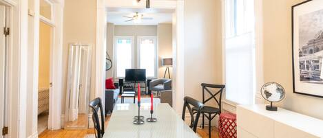 A modern dining area with a rectangular table, chairs, and a ceiling fan.