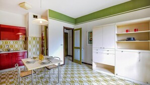 Una cocina con una mesa de comedor, sillas y una lámpara colgante.