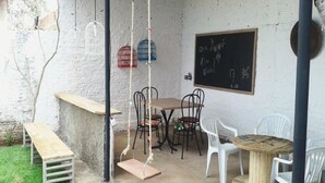 A rustic outdoor seating area with a wooden bench, a swing, and a chalkboard with writing. - Chale near the best clubs, downtown, restaurants and venue. (Caldas Novas)