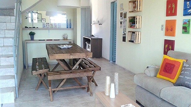 A living room with a wooden dining table, a grey sofa, and a coffee table. - Chale near the best clubs, downtown, restaurants and venue. (Caldas Novas)