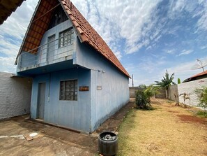 A two-story house with a blue exterior and a red-tiled roof.