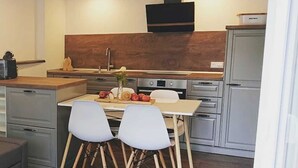Une cuisine moderne avec un coin repas, des meubles en bois et un four encastré.