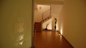 Un pasillo con una escalera que lleva a una plataforma. Hay un cartel en la pared que dice 