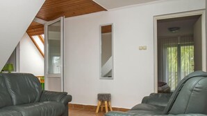 A modern living room with two leather sofas, a small stool, and a large mirror on the wall. - Sapphire by Interhome (Balatonmariafurdo)