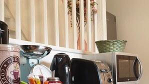 Eine Küchenarbeitsplatte mit Kaffeemaschine, Toaster, Mikrowelle und einem Teller Essen.