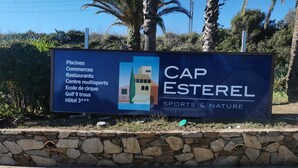 En skylt för Cap Esterel, som visar att området erbjuder bekvämligheter som en golfbana, restauranger och ett sportcenter.